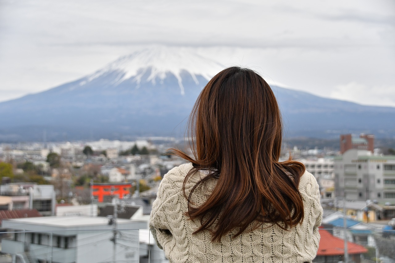 富士山を眺める女性の後ろ姿の写真